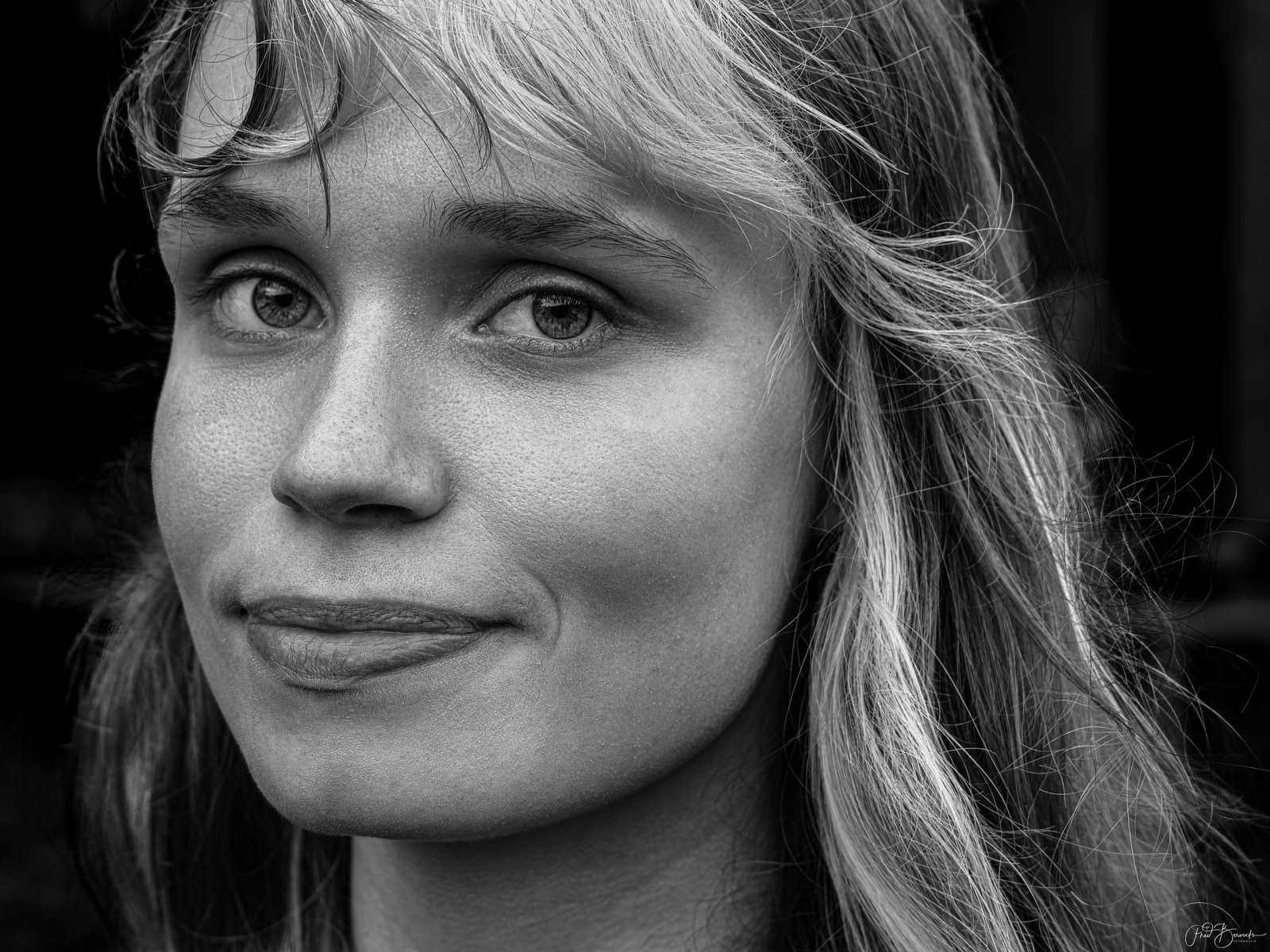 Close-up portrait of a person with long hair, looking directly at the camera.