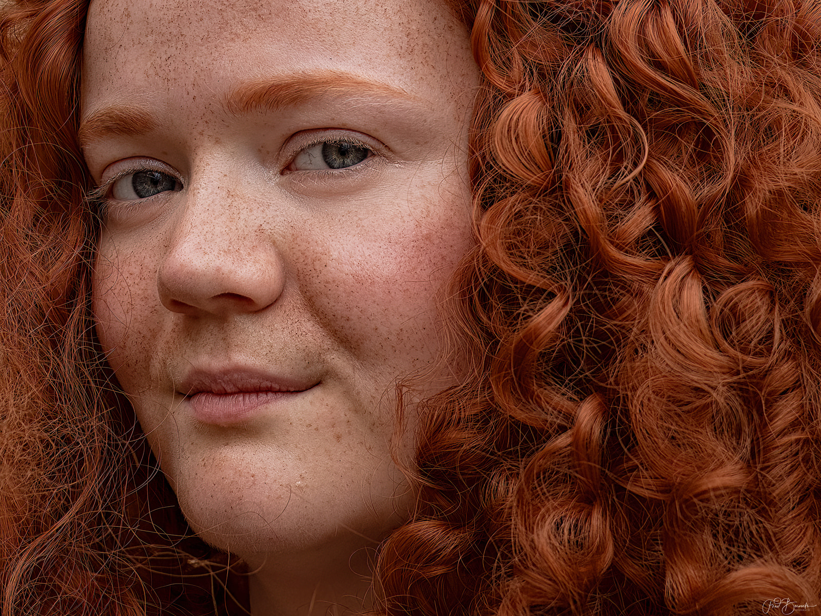 A close-up view of curly red hair framing a person's face.